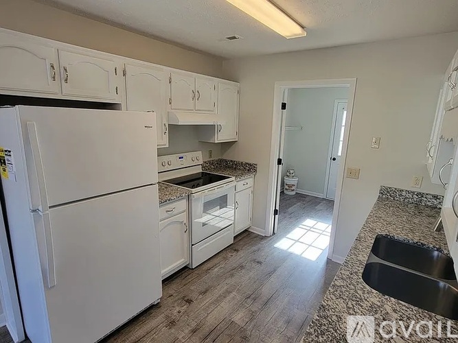 A kitchen with white appliances and cabinets.
