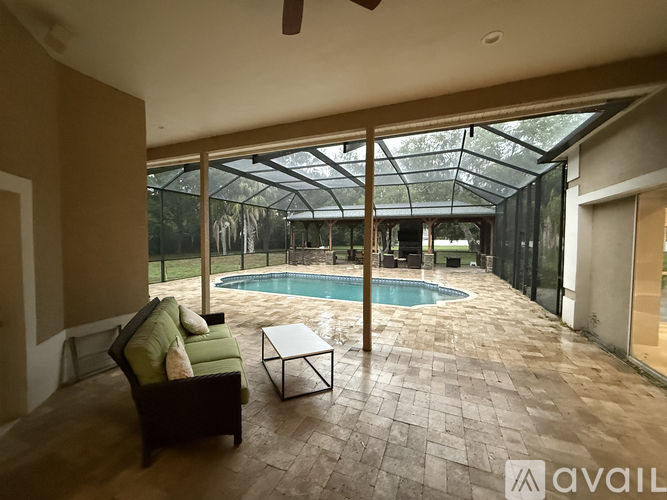 A patio with a pool and a glass roof.
