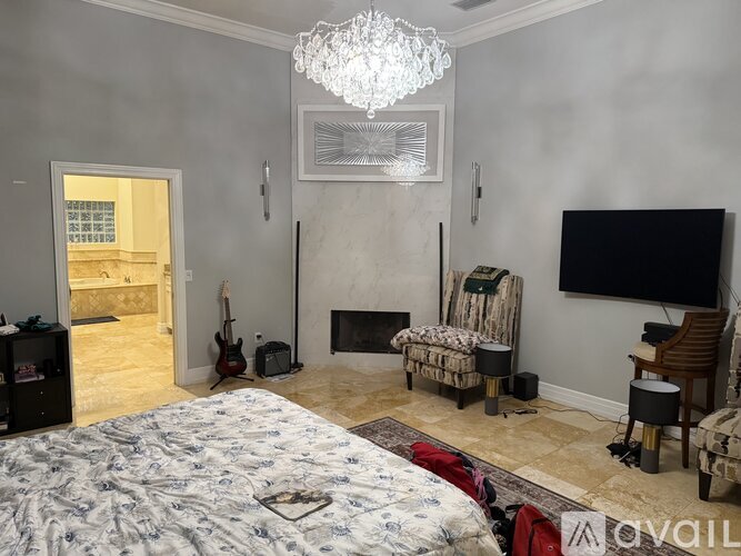 A bedroom with a large bed and a fireplace.