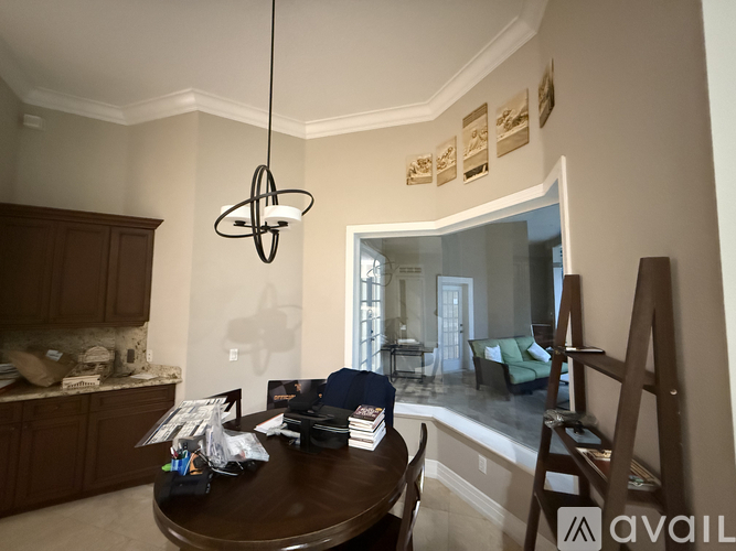 A modern dining room with a dark wood table and a hanging light fixture.