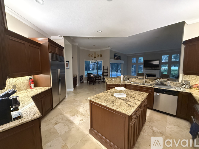 A kitchen with brown cabinets and granite countertops.