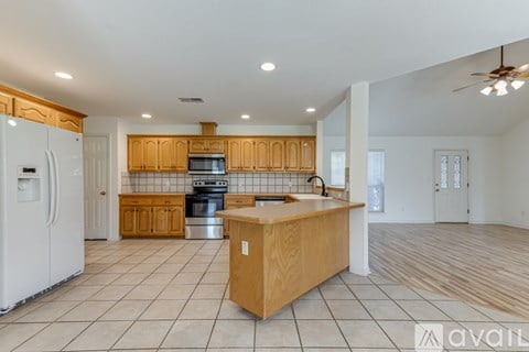 A kitchen with wooden cabinets and a white refrigerator.
