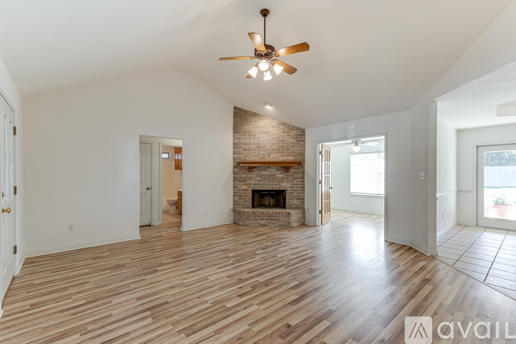 A spacious living room with a fireplace and wooden flooring.