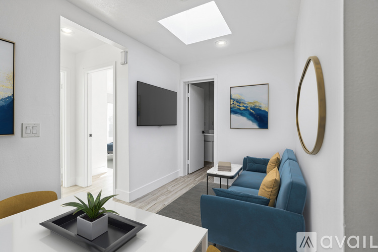 A living room with a blue couch and a flat screen TV mounted on the wall.