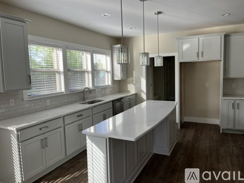 A modern kitchen with white cabinets and a central island.