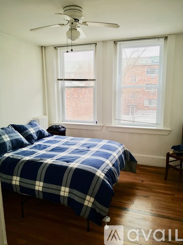 A bedroom with a bed and a ceiling fan.