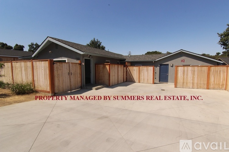 A property managed by Summers Real Estate, Inc. is shown with a clear sky in the background.