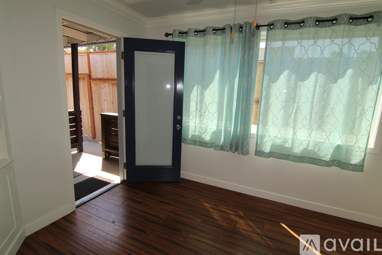 A room with a dark blue door and a window with curtains.