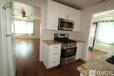 A kitchen with white cabinets and a stainless steel stove.