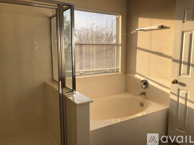 A bathroom with a tub, shower, and window.