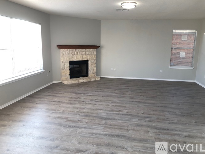 A living room with a fireplace and wood flooring.