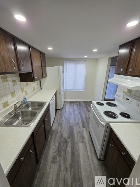 A kitchen with wooden cabinets and a white countertop.