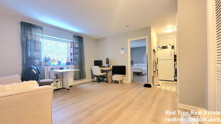 A living room with a couch, a desk, and a chair.