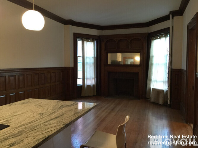 A large, empty room with wood paneling and a fireplace.