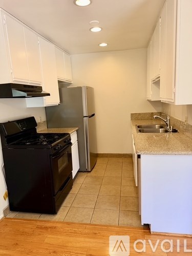 A kitchen with black appliances and white cabinets.