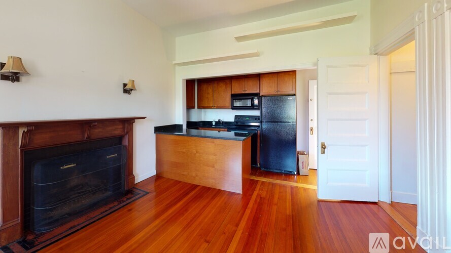 A kitchen with a wood floor and a fireplace.