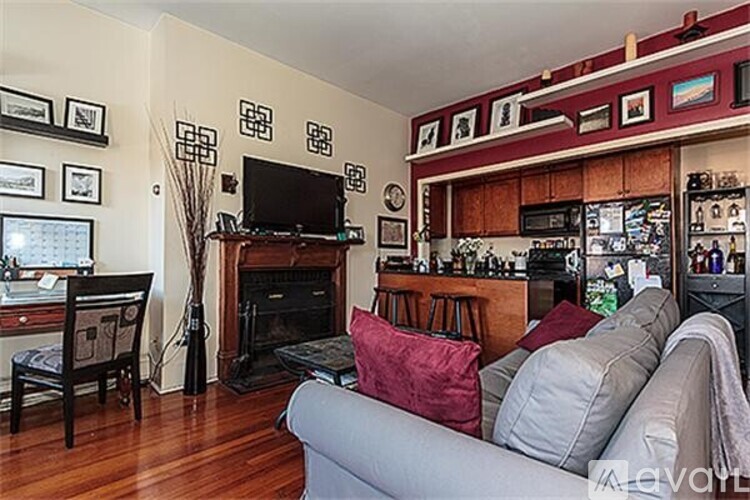 A living room with a grey couch and a fireplace.
