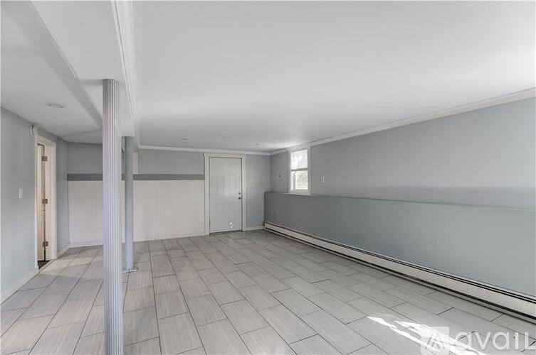 A spacious room with tile flooring and white walls.