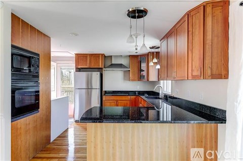 A kitchen with wooden cabinets and a black countertop.