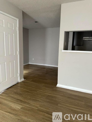 A room with a white door and a window with blinds.