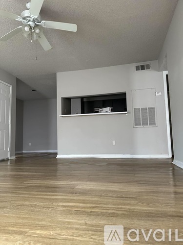 A room with a ceiling fan and wooden flooring.