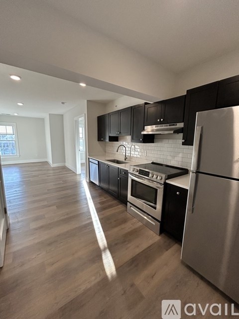 A kitchen with a refrigerator, oven, and stove.