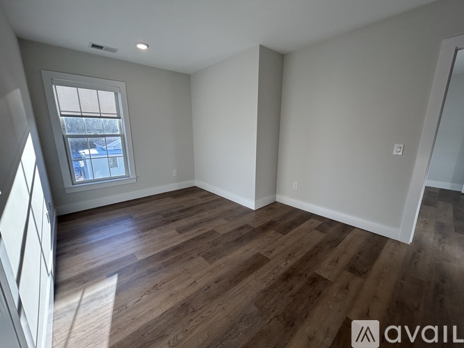 A room with wooden flooring and a window.