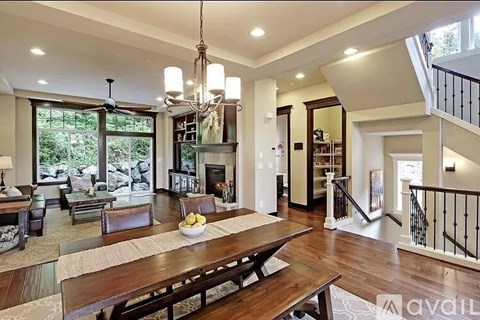A large open living room with a wooden table and chairs.