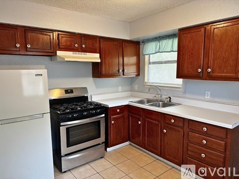 A kitchen with white appliances and wooden cabinets.