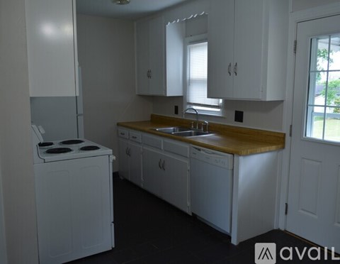 A white kitchen with a washing machine and a window.
