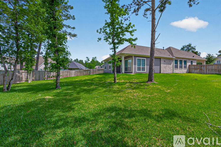 A house with a fence and trees in the front yard.