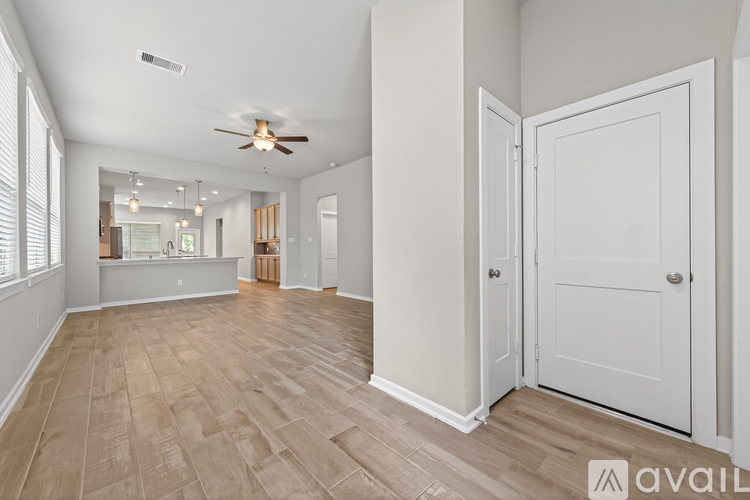 A spacious room with a ceiling fan and lighting fixture.