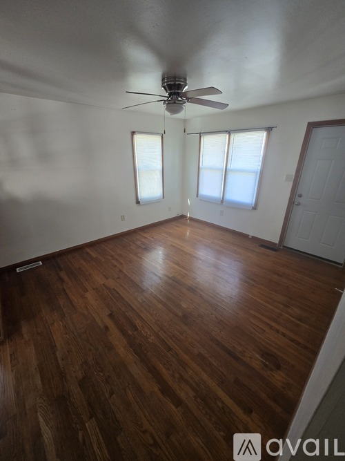 A room with wooden floors and a ceiling fan.