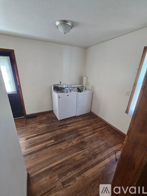 A kitchen area with a white cabinet and a wooden floor.