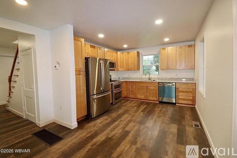 A kitchen with wooden cabinets and a refrigerator.