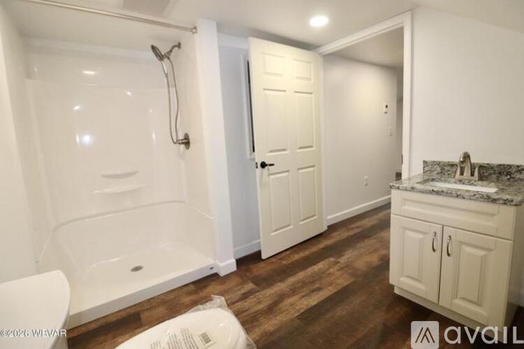 A bathroom with a white tub and a white toilet.