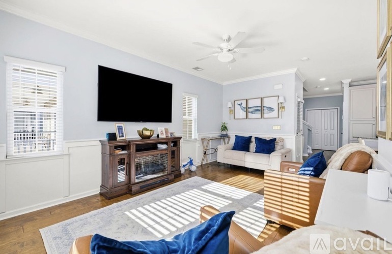 A living room with a white couch and a wooden entertainment center.