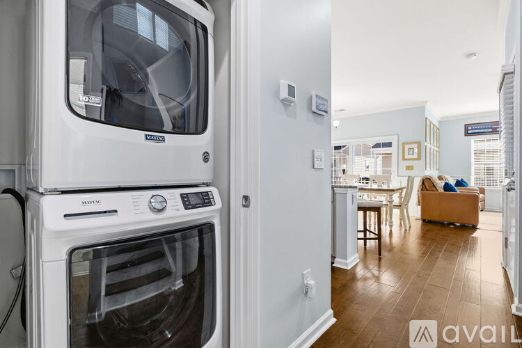 A white dishwasher is in a kitchen with a wooden floor.