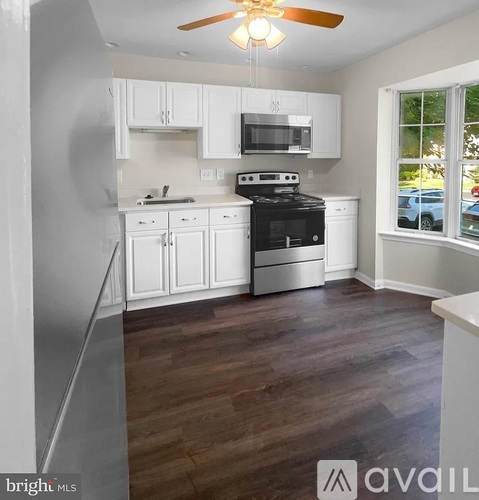 A kitchen with white cabinets and a black stove top oven.
