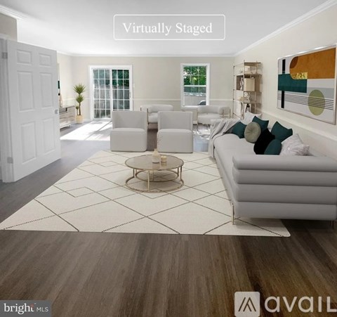 A living room with a white sofa, a coffee table, and a painting on the wall.