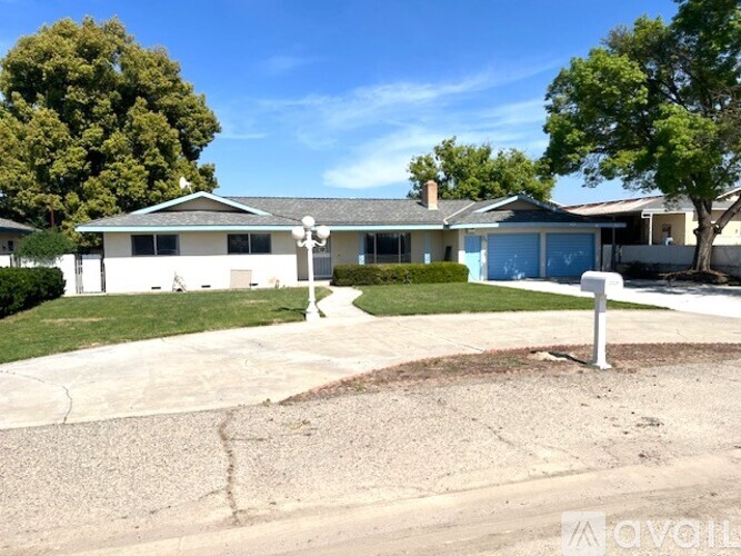 A house with a white fence and a blue garage door.