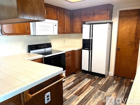 A kitchen with wooden cabinets and a white fridge.