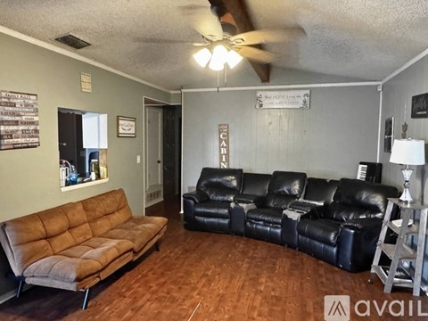 A living room with a brown couch and a black leather couch.