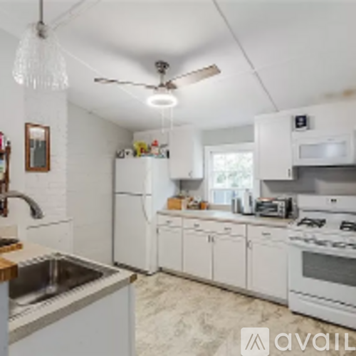 A kitchen with white cabinets and a stainless steel sink.