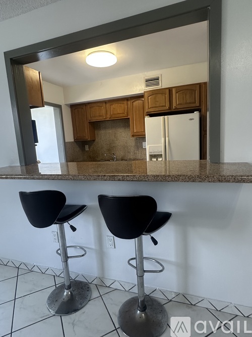 Two black bar stools are in front of a mirror.