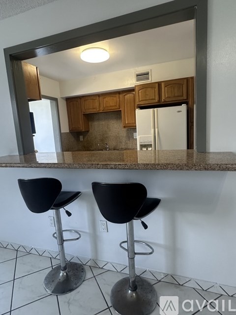 Two black bar stools are in front of a mirror.