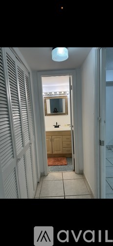 A hallway with white walls and a mirror on the wall.