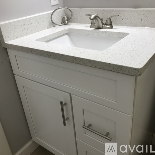 A white bathroom vanity with a sink and a faucet.