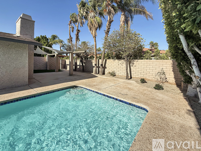 A pool surrounded by a wall and trees.