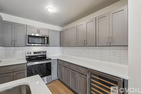 A kitchen with a white counter top and a white sink.